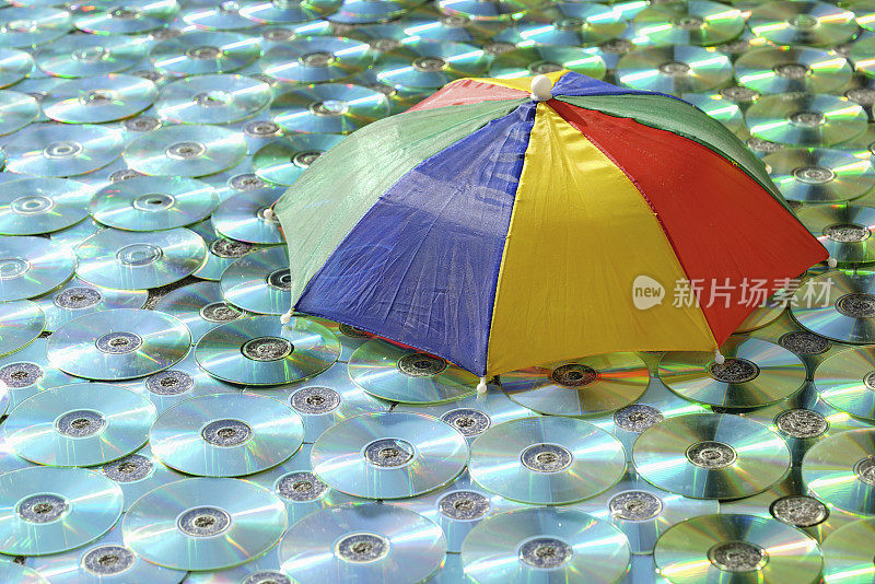 彩色伞和阳光反射的彩色CD/DVD作为纹理背景